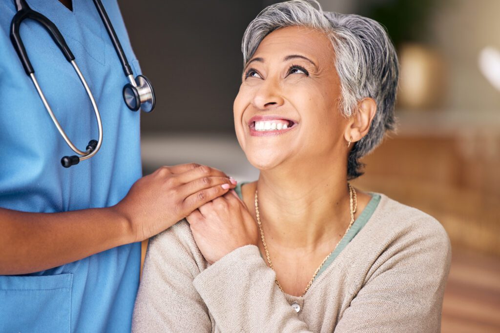 Nurse, senior woman and smile with comfort, holding hands or support in nursing home for retirement. Doctor, medic or caregiver with kindness, empathy or gratitude for help, trust or service in house